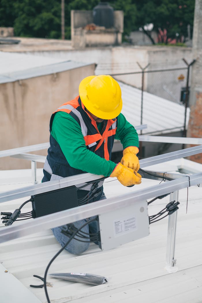 why-choose-us-02 Electrician with PPE working on rooftop solar panel installation, focusing on safety.