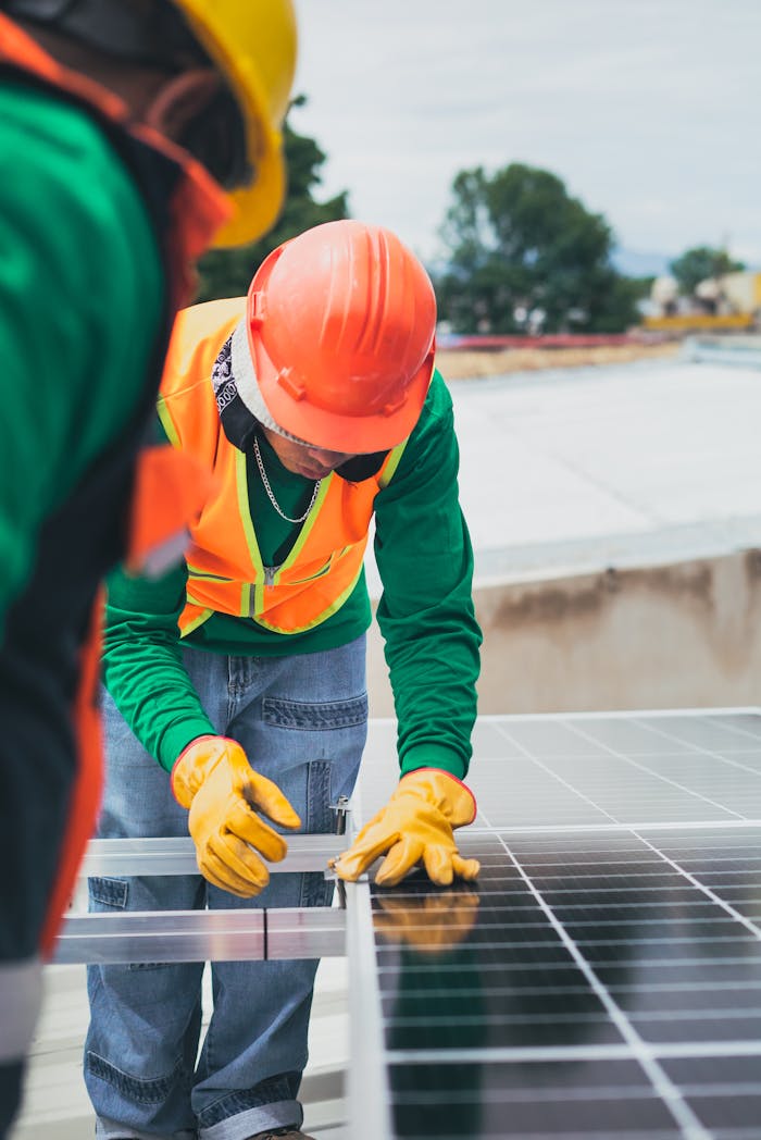 about-06 Worker in safety gear installing solar panels on a rooftop.